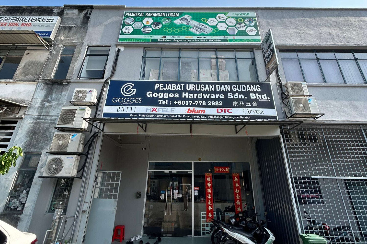 Gogges Hardware Sdn. Bhd. building entrance with signage and cars parked outside.